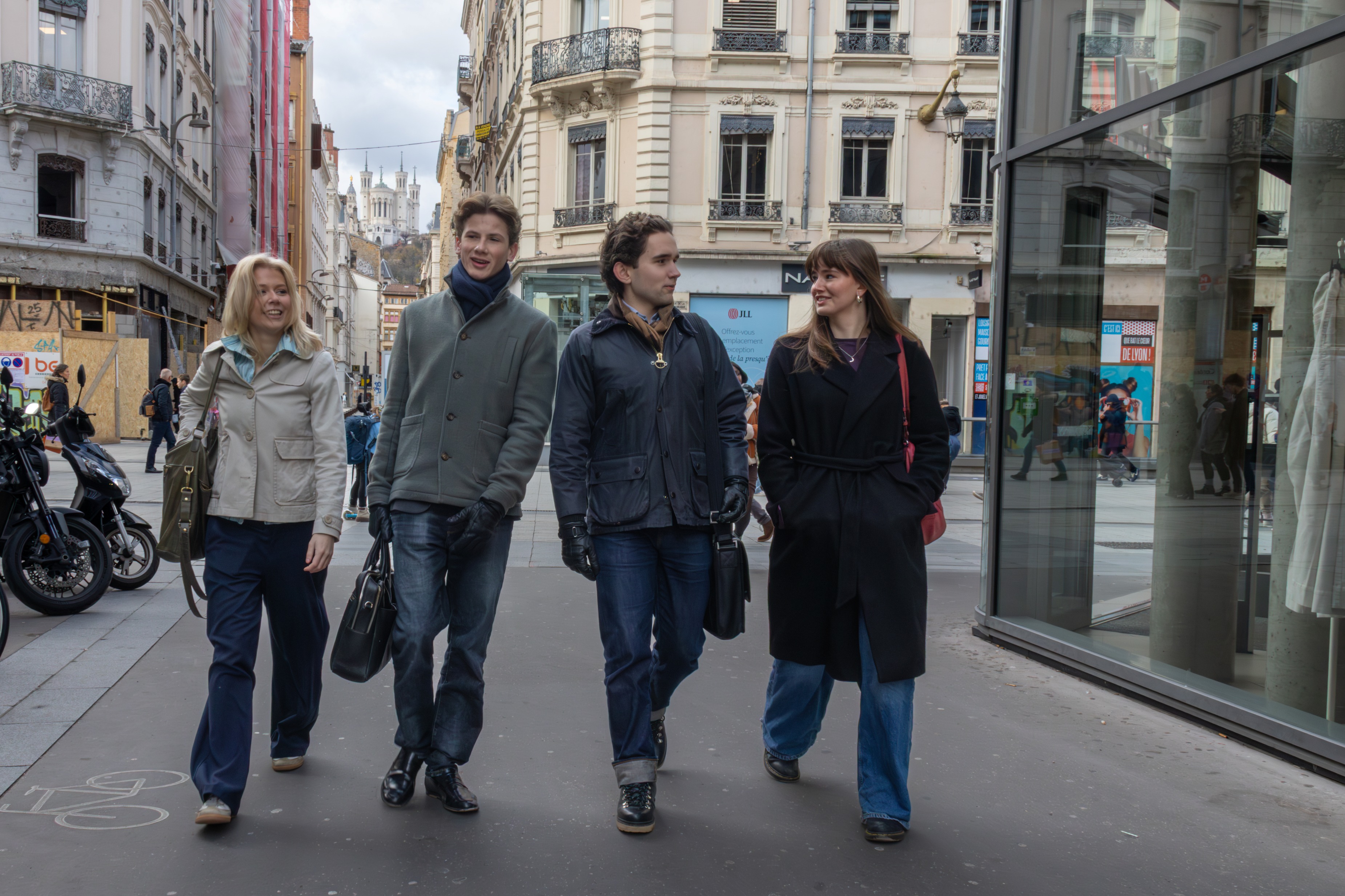 Fire elever spaserer i en by.