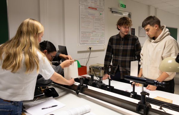 To unge menn og to unge kvinner i et laboratorium.