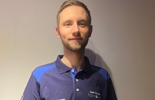 En mann i blå t-skjorte ser rett i kameraet.