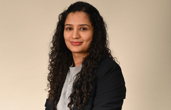 En kvinne med mørkt, krøllete hår.