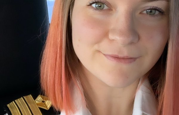 Dame med hvit uniformsskjorte ser inn i kamera