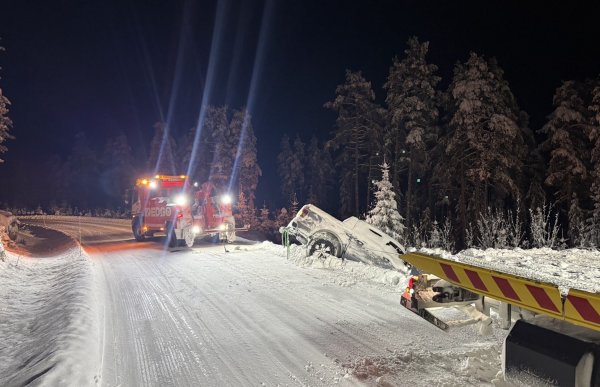 Bilberging på vinteren. En pickup har kjørt i grøfta med fronten rett ned. Det er vinter, mørkt og skog rundt veien. Bilbergeren prøver å dra bilen opp av grøfta.  