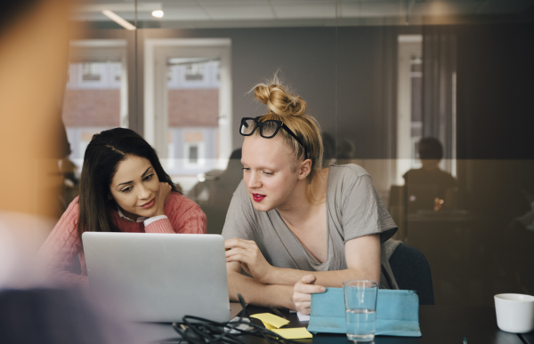 To mennesker på et kontor, diskuterer en tekst på en datamaskin