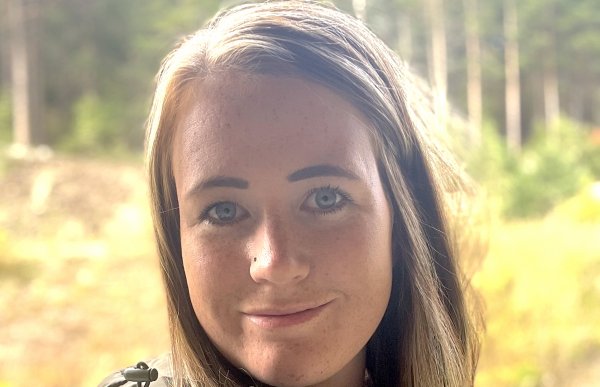 Portrettbilde av en kvinne med brunt hår og ullgenser på.