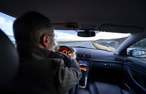 Sjåfør bak rattet i personbil.