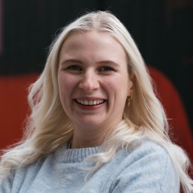 En dame med blondt hår og lyseblå ullgenser.