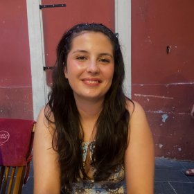 Frida En ung kvinne med langt svart hår. Hun smiler.