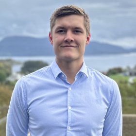 Industrimontør Håvard Vik Mann med lyst, kort hår og lyseblå skjorte ser inn i kamera
