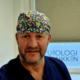 Mann med skjegg og tørkle på hodet. Han er på legekontor.