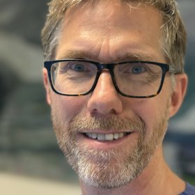 Lungespesialist Erik Dyb Liaaen Mann med briller, skjegg og kort hår. Blå skjorte.