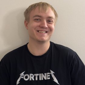 Lyshåret mann med svart t-skjorte står foran en hvit vegg