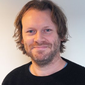 Professor Anders Nordahl-Hansen En mann i midten av 40-årene med lys hud og blå øyne ser rett mot kamera. Han har kort til middels langt, brunt, litt bølgete hår og et skjegg som dekker underkjeven og kinnene. Han smiler svakt. Han har på seg en svart, ribbestrikket genser over en lys blå t-skjorte. Bakgrunnen er enkel og lys.