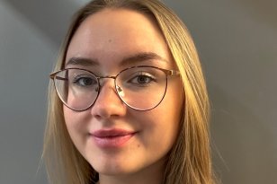 Dame med briller og svart genser ser inn i kamera