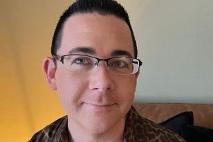 Kreftsykepleier Fredrik von Löwensprung Eiesland En mann med kort, mørkt hår og briller smiler rolig mot kamera. Han har på seg en brun skjorte med leopardmønster og sitter foran en lys gul vegg.