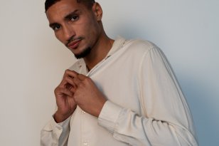 Modell Josef Meliane Mann i hvit skjorte. Han poserer og ser i kamera.