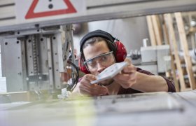 En modellbygger studerer en modellbit