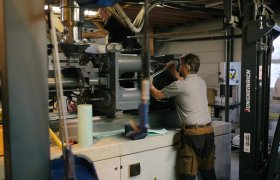 En mann i arbeidsklær med en stor skiftnøkkel i en maskin