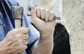 Mann bearbeider stein 