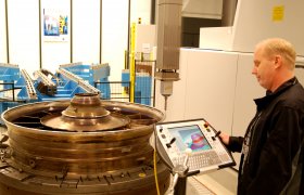 Mann kontrollerer målinger på en skjerm.