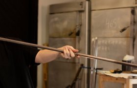 Glasshåndverker blåser glass