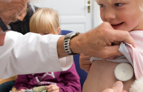 En kardiolog lytter med et stetoskop på hjertet til en jente