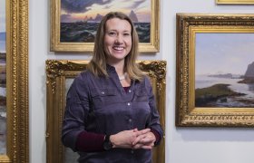 Kunsthistoriker foran malerier.