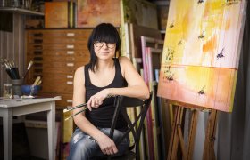 Kunstner sitter ved maleri