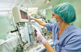 En perfusjonist følger med på en maskin under en hjerteoperasjon