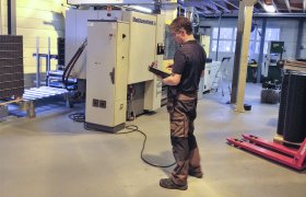 Mann står i plastmekanikerverksted. 