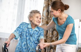 Pleiemedarbeider hjelper eldre kvinne