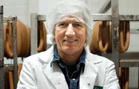 Pølsemaker mellom to rader med pølser