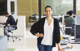 Salgssjef på jobb med salgsteam i bakgrunnen.