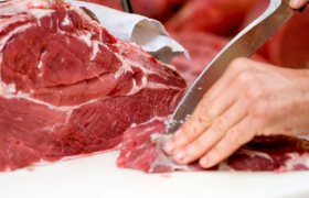 Slakter skjærer et kjøttstykke