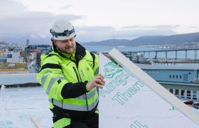 Taktekker i arbeid på et tak.