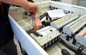 Tavlemontør i arbeid på elektrotavle. 