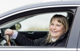 Taxisjåfør sitter i førersetet på en bil