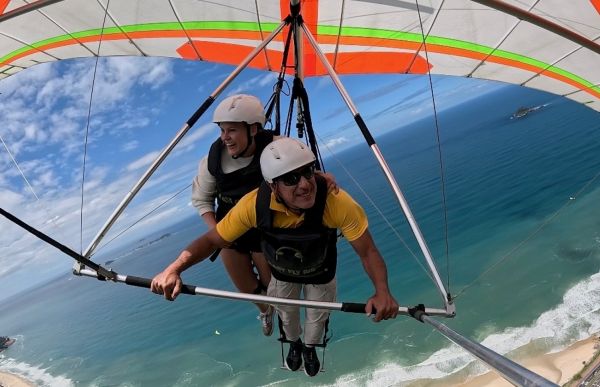 To personer henger under en fargesprakende hangglider